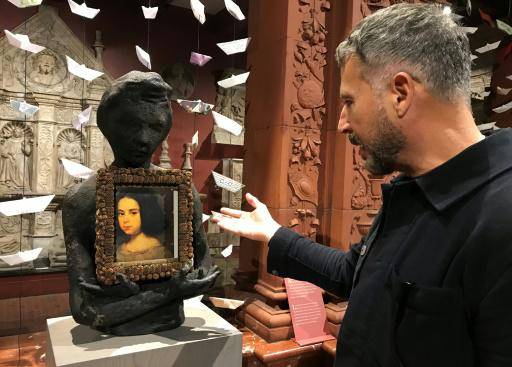 El artista cubano Enrique Martínez Celaya contempla su primer cuaderno escolar, forrado con una foto de la pintura de Diego Velázquez Retrato de una niña, en el Museo Hispanic Society, en Nueva York, el 17 de abril de 2024