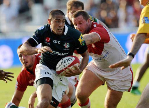 El jugador del Biarritz Campbell Johnstone (drcha.) intenta detener a Dan Bowden, del Irish (izq.), en un partido amistoso de rugby jugado en la ciudad del suroeste de Francia el 19 de agosto de 2011