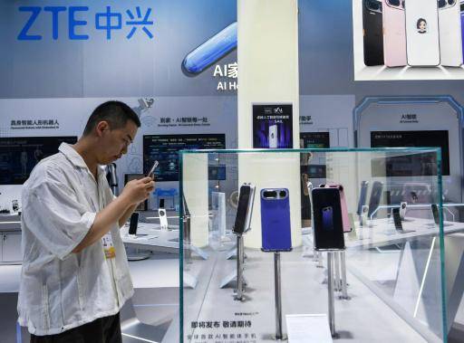 Un hombre observa un teléfono con IA lanzado por ZTE y ByteDance, el 17 de julio de 2026 en una feria tecnológica en Shanghái