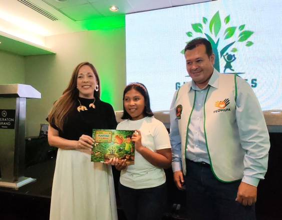 ML | Entregan uno de los libros a una niña presente en el lanzamiento del programa.