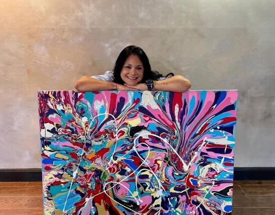 Cortesía | La emprendedora Julia Lugo junto a una pintura.