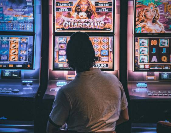 Pexels | Una persona juega en máquinas tragamonedas en un casino.