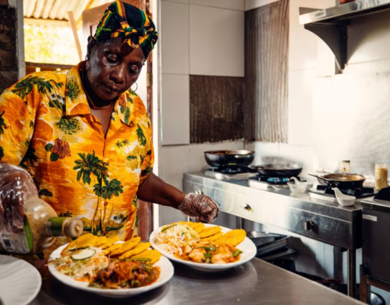 MiCultura | La cocinera colocándole salsa a los platillos.