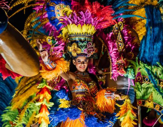 Foto cortesía ATP | Una reina de Carnaval se pasea ataviada con un vestido tradicional de plumas de diferentes colores.