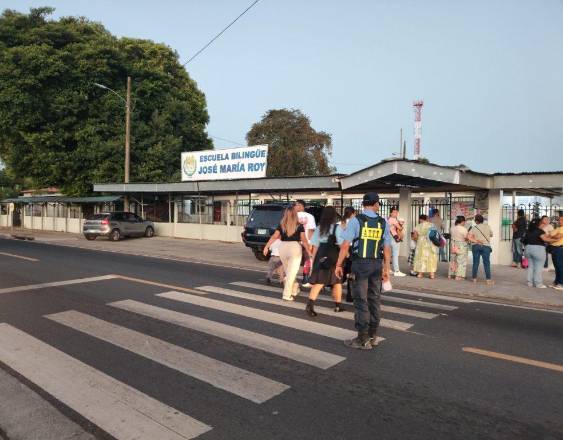 ATTT | Una unidad del tránsito ayudando a las personas a cruzar la calle frente a una escuela.