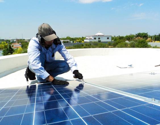 PIXABAY | Un hombre instalan un sistema de panel solar.
