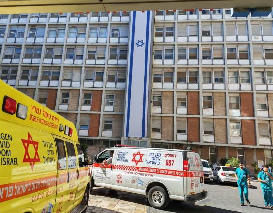 ML | Dos médicos pasan junto a Varias ambulancias estacionadas frente al innovador Hospital Universitario Hadassah, en Jerusalén.