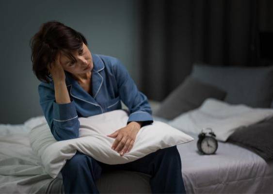 Freepik | Una persona sentada en la cama sin poder dormir.