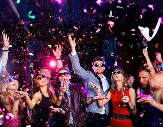 Freepik | Un grupo de amigos felices celebrando Año Nuevo en una discoteca con una escena vibrante de alegría, baile y unión.