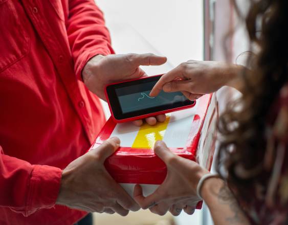 PEXELS | Una persona entregando un paquete de comida.