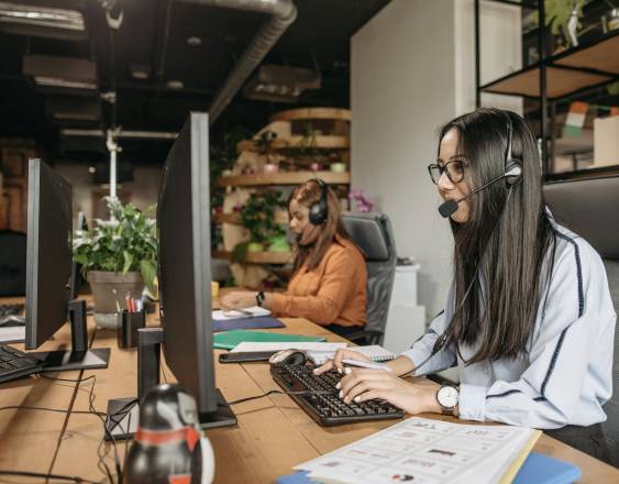 PEXELS | Personas que trabajan en una agencia de cobros llaman a clientes para que realicen sus pagos.