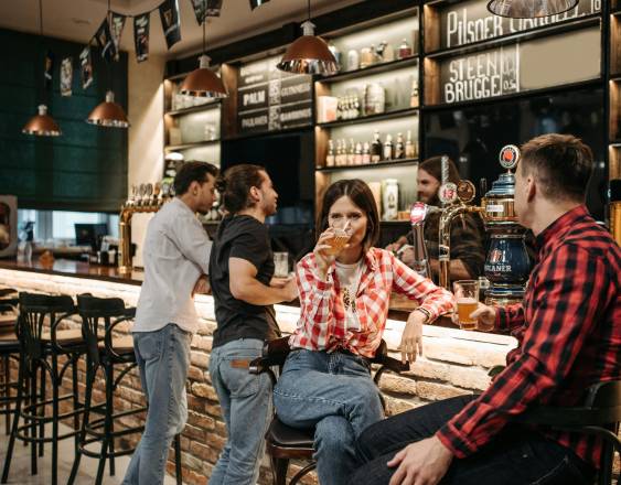 Pexels | Un pequeño grupo de jóvenes en la barra de un bar.