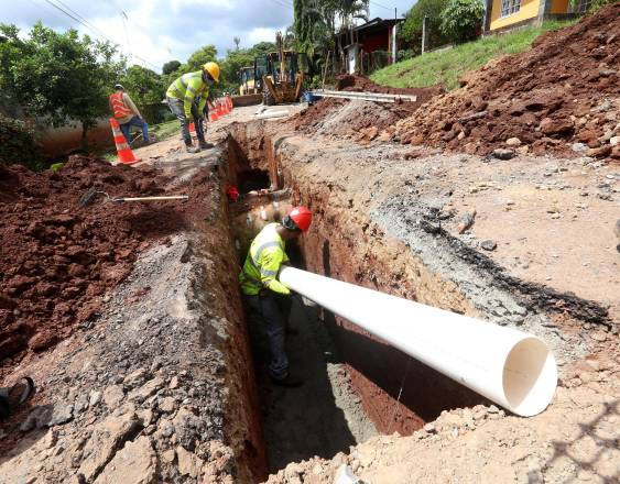 Cortesía | Trabajadores instalando una tubería de gran tamaño bajo una carretera.