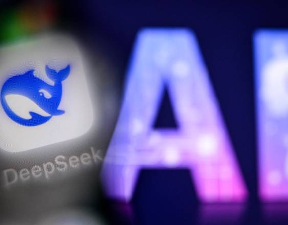 Las letras AI (inteligencia artificial) parpadeando en la pantalla de una computadora portátil (R) junto al logotipo de la empresa emergente china de inteligencia artificial DeepSeek.