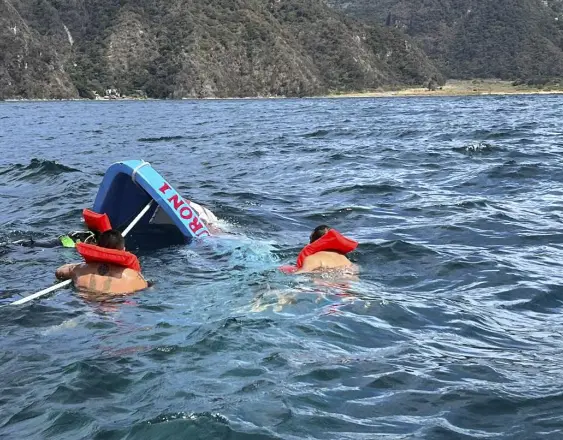 Hombres Rana realizando operaciones de rescate en la pequeña embarcación que naufragó en el lago Atitlán, en Panajachel, Guatemala.