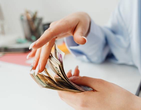 PEXELS | Una persona contando el dinero para realizar el pago de una deuda.