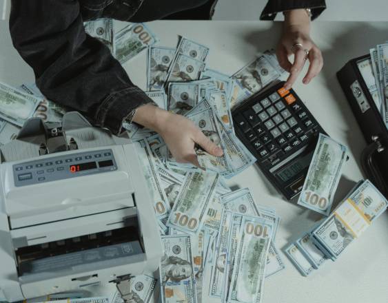 PEXELS | Una persona cuenta varios billetes de 100 dólares.