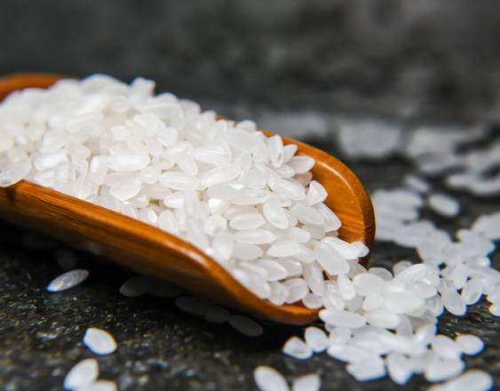 PEXELS | Una cuchara de madera con granos de arroz.