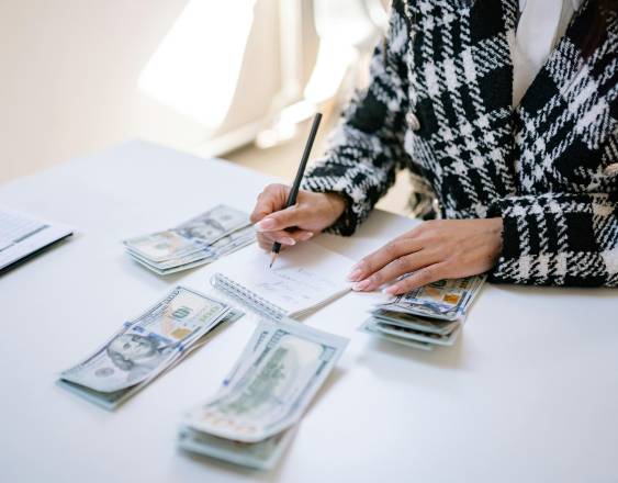 PEXELS | Una mujer cuenta su dinero para pagar compromisos.