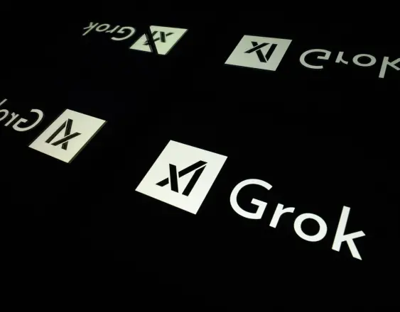 Pantallas con el logotipo de Grok, un chatbot de inteligencia artificial generativa.
