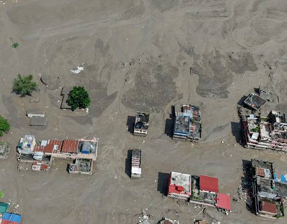 Casas yacen parcialmente sumergidas en aguas fangosas a orillas de un río tras unas inundaciones repentinas en Trishuli Bazar, en el distrito nepalí de Nuwakot.