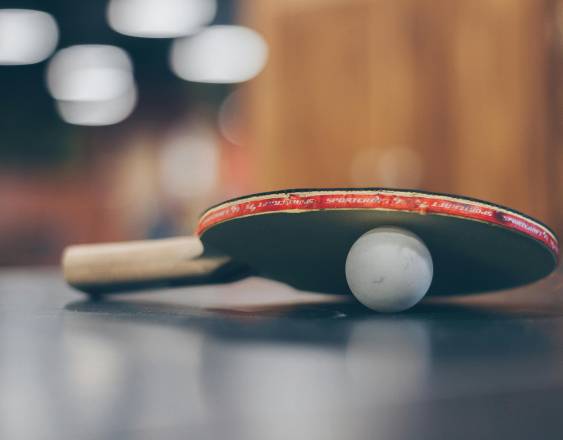 Pexels | Una paleta de tenis y la bola sobre una mesa.