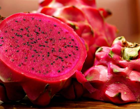 PEXELS | Una pitahaya abierta muestra su pulpa llena de semillas, mientras otra permanece cerrada.