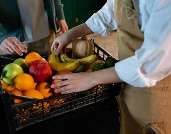 PEXELS | Un comerciante recibiendo una caja con frutas y verduras.