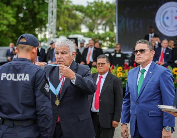 ML | El presidente entregando una medalla a un graduando.
