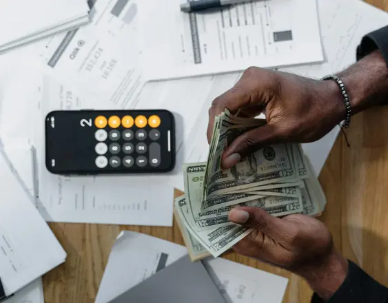 PEXELS | Una persona sostiene varios billetes de 20 dólares en sus manos.