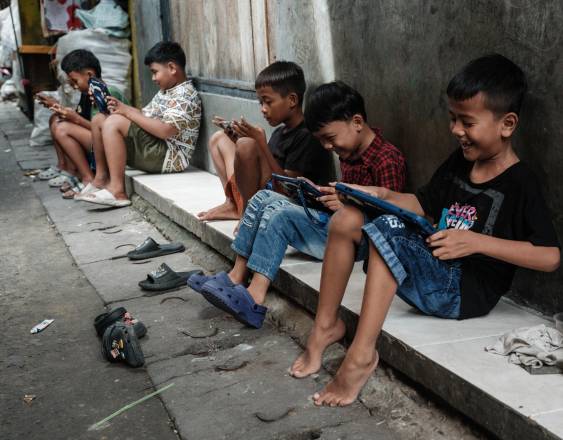 AFP | NIños de diversas edades mirando aplicaciones de redes sociales en tabletas y teléfonos.