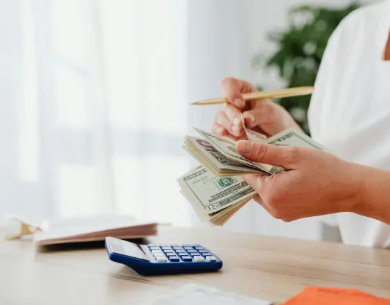 PIXABAY | Una persona contando dinero y sacando cuentas con una calculadora para llevar un registro de los fondos recibidos. Los datos son registrados de forma digital.