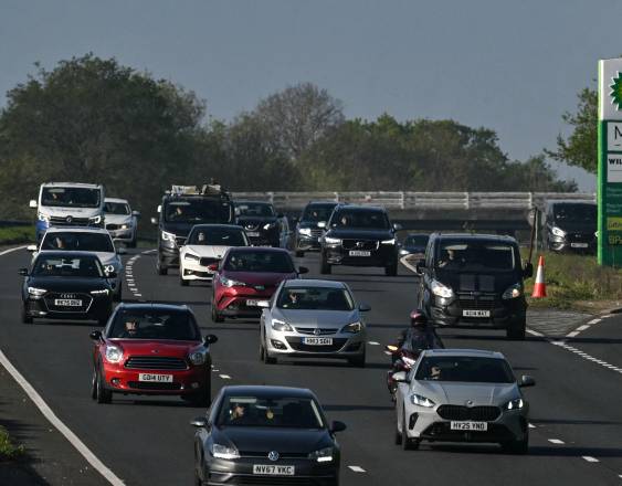 AFP | Los vehículos pasan junto a una gasolinera mientras circulan por la A3 durante la hora punta de la mañana cerca de Ripley, al suroeste de Londres.