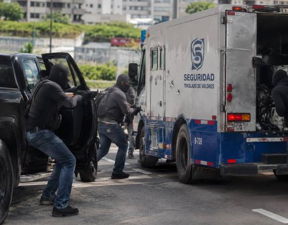 Cortesía | Asaltante robando un camión blindado que está detenido frente a un banco.