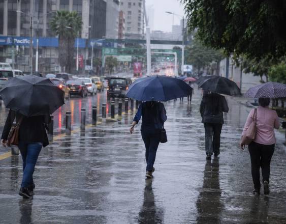 Cortesía | Personas con paraguas mientras cae el agua.