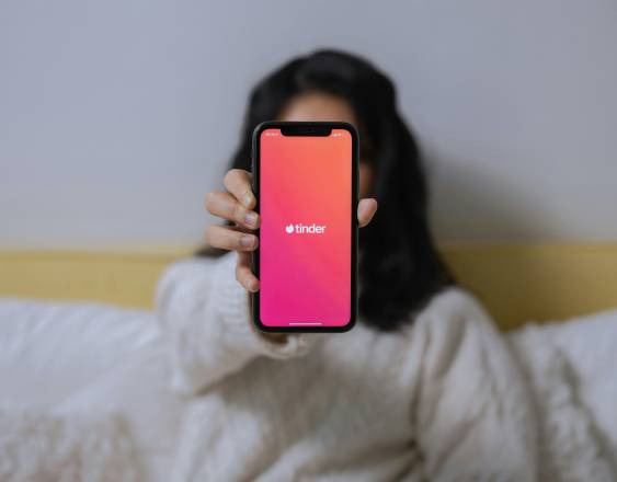 Pexels | Una persona muestra su smartphone con una app de citas.