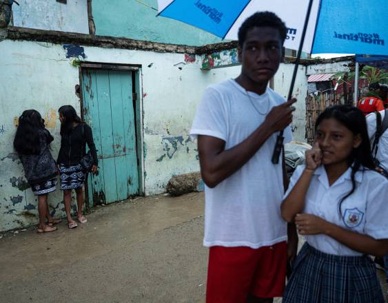 AFP | Indígenas guna caminan bajo la lluvia en la isla Carti Sugtupu, en la comarca Guna Yala, en la costa caribeña de Panamá.