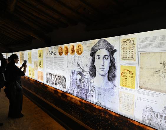 AFP | La gente se coloca frente a imágenes que representan la historia del artista Rafael, durante la vista previa para la prensa del proyecto “Más allá de lo visible”, promocionado conjuntamente con Eni, dentro de las cúpulas en la azotea del Vaticano, el 16 de febrero de 2026.