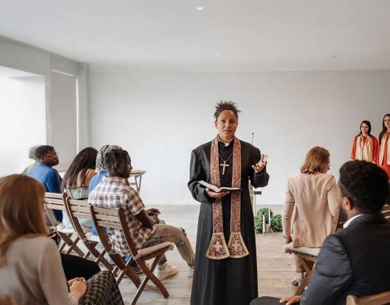 Pexels | Una pastora en medio de la iglesia llevando un mensajes de fe o enseñanzas para el ministerio pastoral de su comunidad.