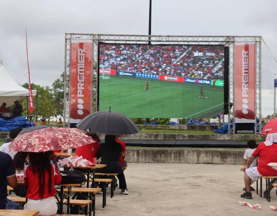 ML | Personas disfrutando un partido en pantalla grande.