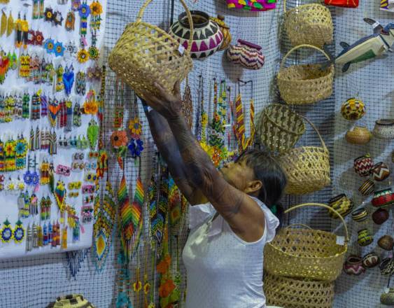 ML | Una artesana acomodando una cesta de fibra natural en su puesto de venta.