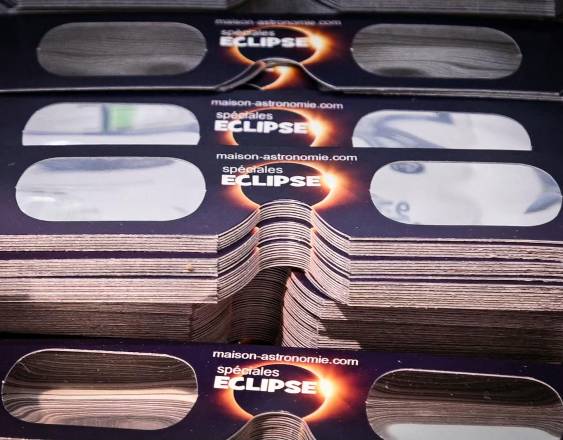 Gran cantidad de gafas para observar eclipses solares exhibidas en una tienda especializada en optometría conductual.