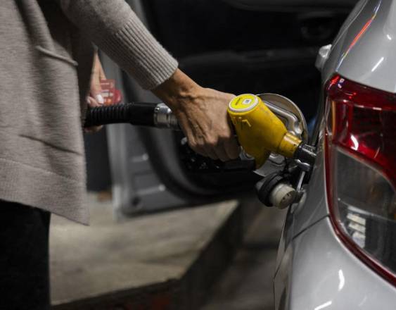 AFP | Una persona surtiendo de diésel su vehículo en una estación de combustible.