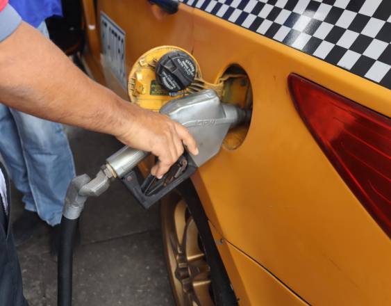 ML | Una persona cargando combustible a un taxi.