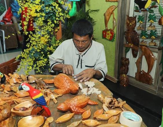 MiCultura | Artesano creando tortugas de madera en la feria.