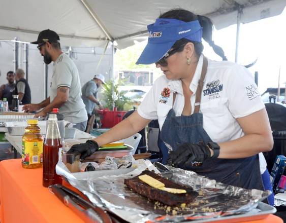 Cortesía | Una participante prepara un corte de carne ahumada.