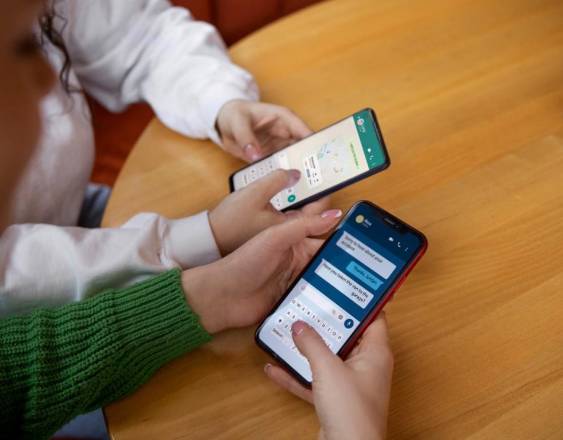 Freepik | Dos mujeres utilizan sus celulares.