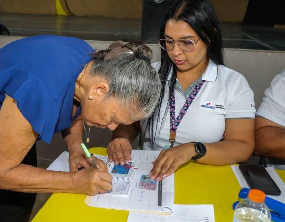 Cortesía | Una adulta mayor recibiendo su pago.
