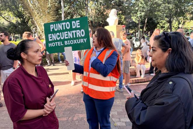 AFP | Una mujer con un letrero de punto de encuentro tras un sismo.