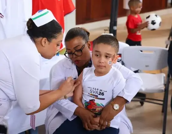 ML | Un niño recibiendo una dosis de vacuna por personal de salud.